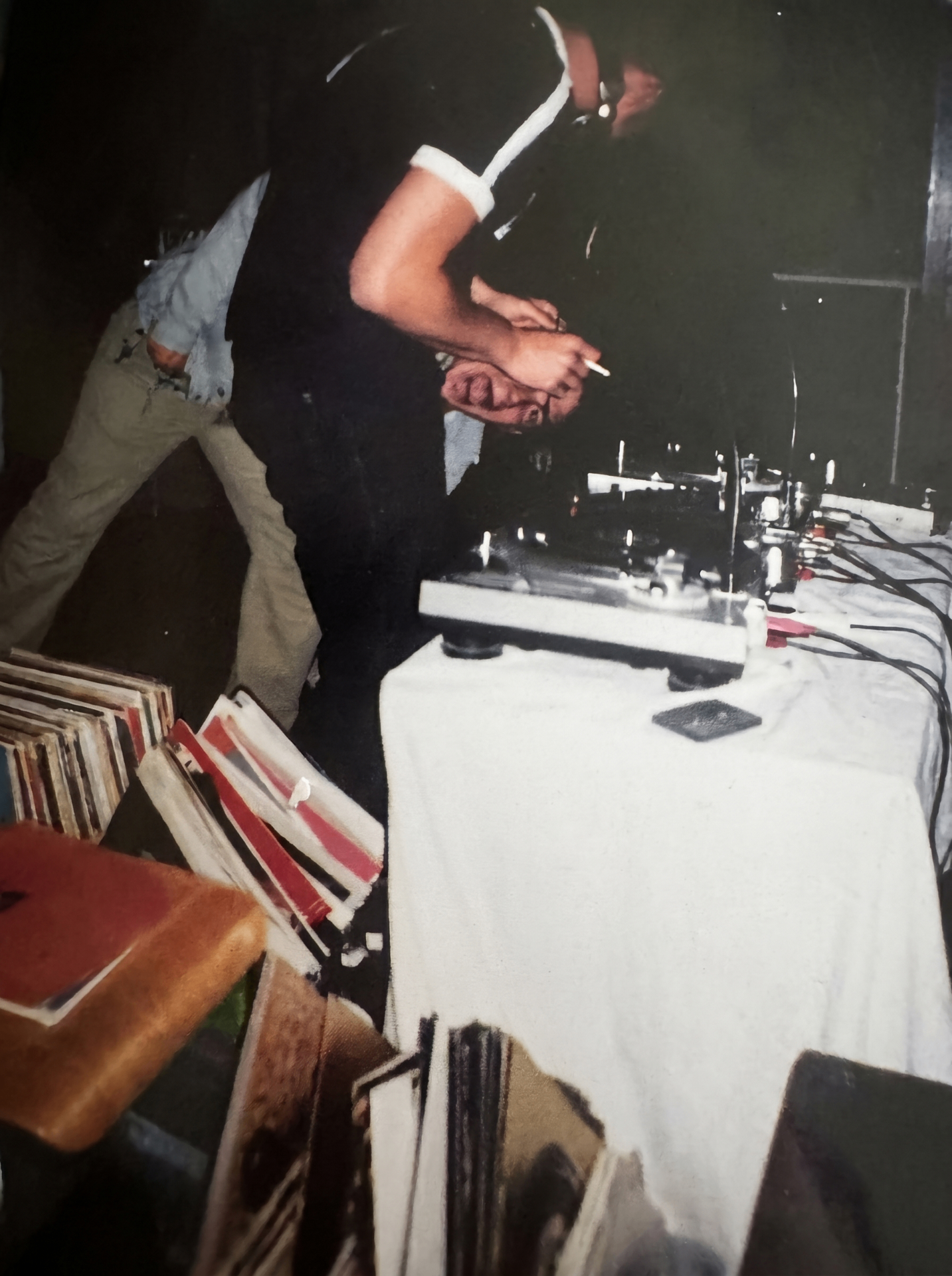 Junger DJ an den Plattenspielern mit Vinyl-Sammlung